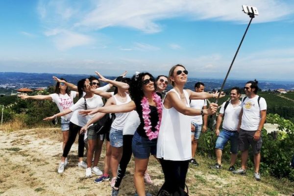 Ragazzi e ragazze si scattano un selfie. Sono un gruppo sulle colline delle Langhe