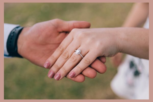 simbolo-amore-fidanzamento Due mani che si intrecciano mostrando un anello di fidanzamento